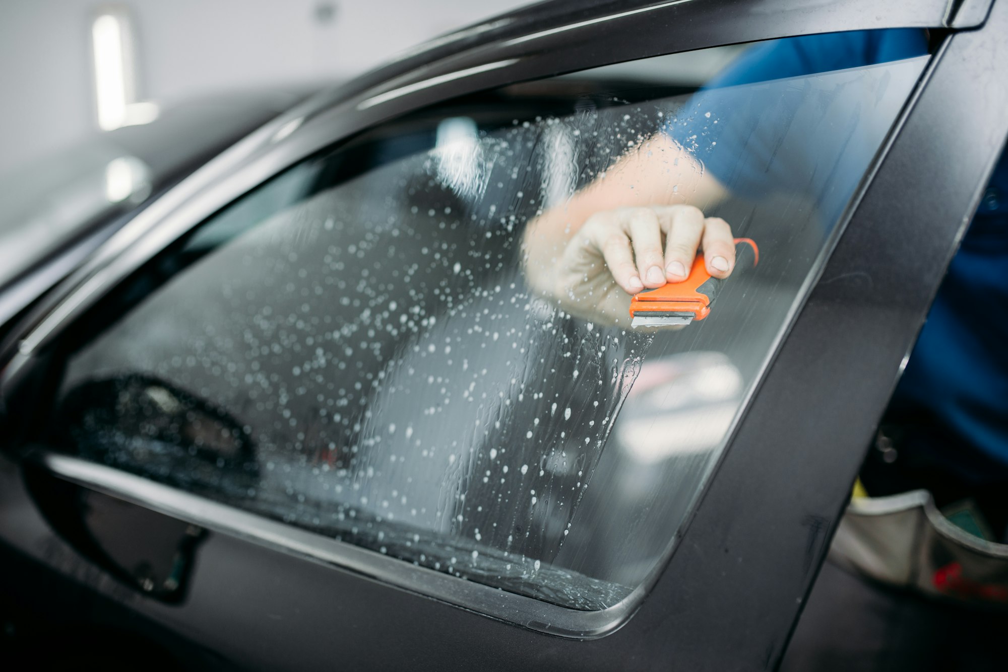 Specialist work with car, tinting film installing